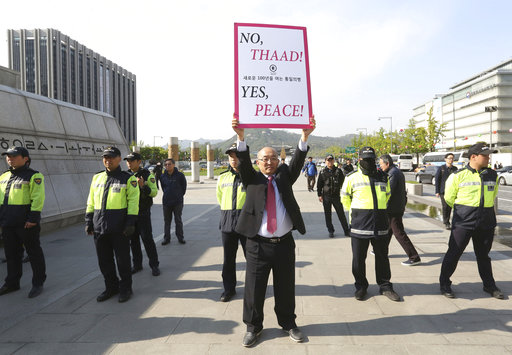 A South Korean protester holds up a placard opposing a plan to deploy the advanced U.S. missile defense system called Terminal High-Altitude Area Defense