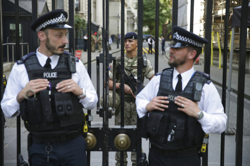 A soldier joins armed police officers guarding Downing Street in London