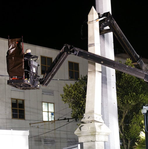 Workers dismantle the Liberty Place monument Monday