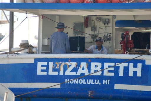 Fishermen stand on a boat at Pier 38 in Honolulu
