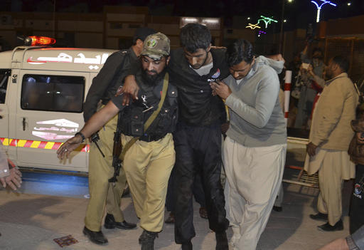 A Pakistani volunteer and a police officer rush an injured person to a hospital in Quetta