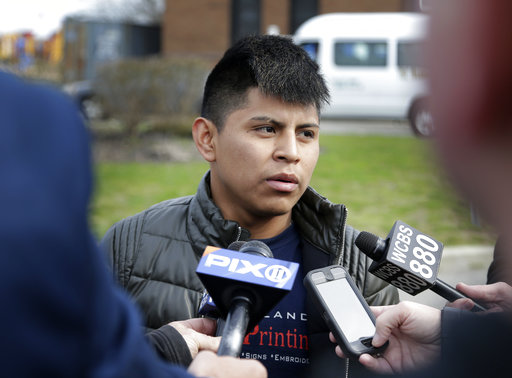 William Tigre talks to reporters at a crime scene where the bodies of four men were found in Central Islip