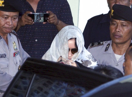 Australian drug smuggler Schapelle Corby covered her head with a scarf gets on a car as she leaves the parole office in Bali