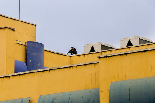 A Spanish national police officer inspect the rooftop of a detention center where nearly 40 migrants have ended an overnight protest in Madrid