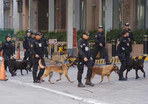 Bomb sniffing dogs walk outside a hotel at the Resorts World Manila complex