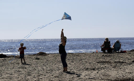 Visitors fly a kite at Natural Bridges State Beach Wednesday