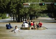 People evacuate a neighborhood inundated after water was released from nearby Addicks Reservoir when it reached capacity due to Tropical Storm Harvey on Wednesday