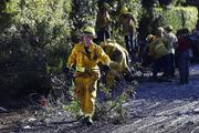 A firefighter cleans debris from an area damaged by storms in Montecito