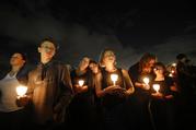 People participate in a candlelight vigil in memory of the 17 students and faculty who were killed in the Wednesday mass shooting at Marjory Stoneman Douglas High School in Parkland