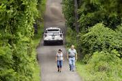 Law enforcement officials walk down a blocked off driveway in Solebury
