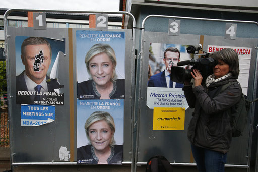 A reporter videos outside the voting station in Henin Beaumont
