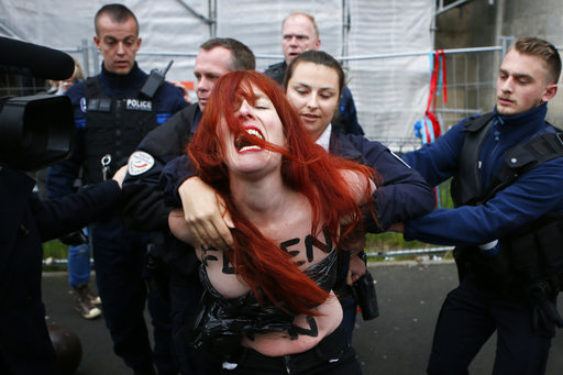 A Femen activist is led away by French police in Henin-beaumont