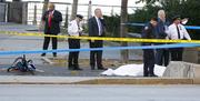 Authorities investigate the scene around a body covered under a white sheet next to a mangled bike along the bike path Tuesday Oct. 31