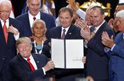President Donald Trump holds up a signed proclamation to shrink the size of Bears Ears and Grand Staircase Escalante national monuments at the Utah State Capitol Monday