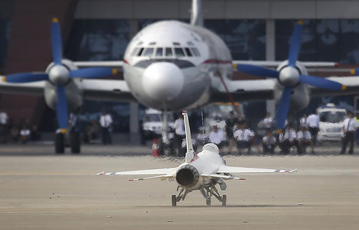 A remote-controlled F-16 fighter jet lands in front of an Air Koryo commercial airplane at the Kalma Airport after a flight demonstration on Sunday