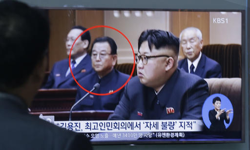 A man watches a TV screen showing a file image of Kim Yong Jin