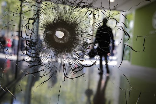 A bullet hole is pictured on a shopwindow of the Champs Elysees boulevard in Paris
