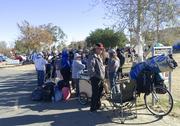 Homeless people line up in preparation to move from their homeless camp site along a riverbed in Anaheim