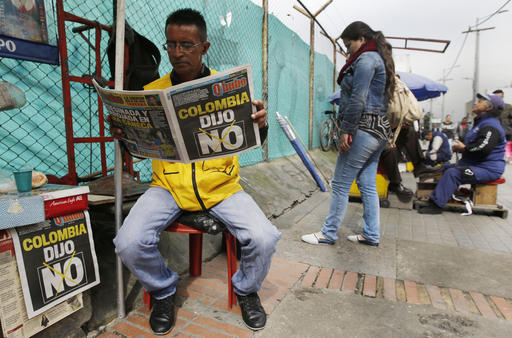 A man reads a newspaper with the headline that reads in Spanish: "Colombia said No" in Bogota