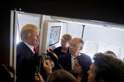 U.S. President Donald Trump speaks to reporters aboard Air Force One