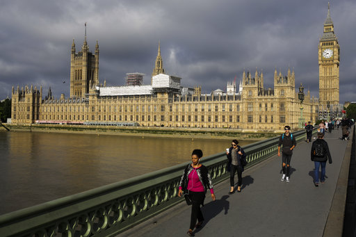 People cross Westminster Bridge in front of the Houses of Parliament the day after Britain's national elections on London