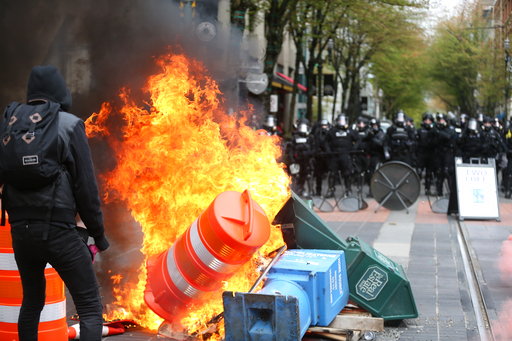 Police try to disperse people participating in a May Day rally in downtown Portland