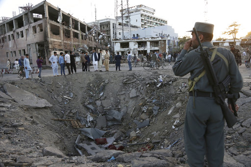 Security forces stand next to a crater created by massive explosion in front of the German Embassy in Kabul