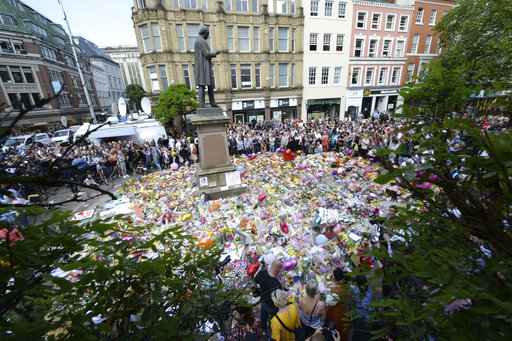 People hold a minute of silence in a square in central Manchester