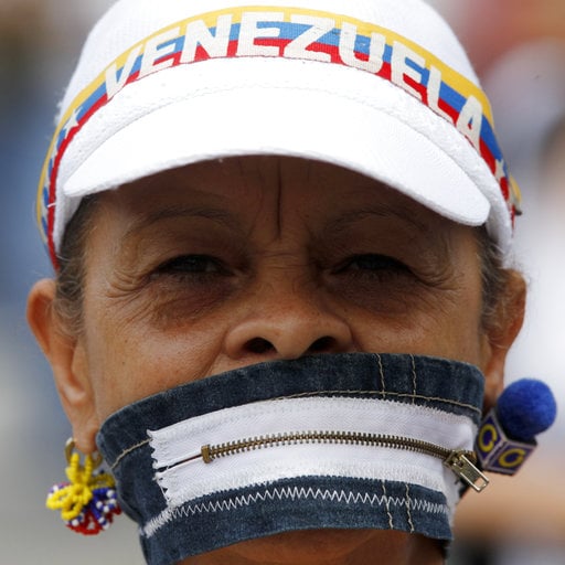 An anti-government protesters covers her mouth with a zipper during a women march against repression in Caracas