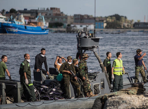Egyptian coast guard and rescue workers bring ashore bodies recovered from a Europe-bound boat that capsized off Egypts Mediterranean coast