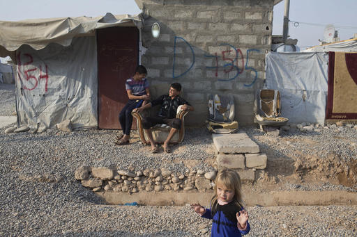 Children converse inside the Baharka camp for displaced persons on the outskirts of Irbil