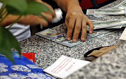 A man cleans U.S dollars with cotton wool at his currency exchange shop