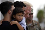 President Donald Trump poses for a photo as he visits a disaster relief distribution center at Calgary Chapel in Guaynabo