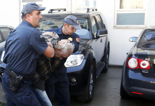 Montenegrin police officers escort a suspected man in Podgorica