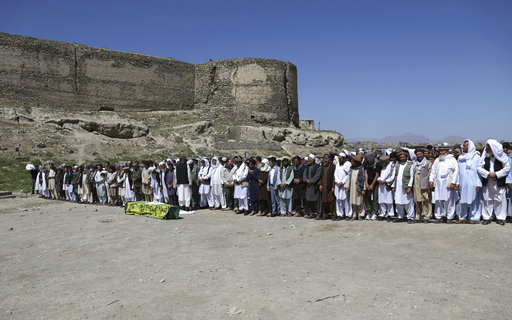 Afghans pray during the funeral of a victim who died in Wednesday's massive bombing