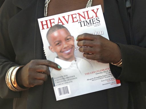 Mourners hold the commemorative program as they emerge from the funeral service for 15-year-old