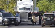 San Antonio police officers investigate the scene where eight people were found dead in a tractor-trailer loaded with at least 30 others outside a Walmart store in stifling summer heat in what police are calling a horrific human trafficking case