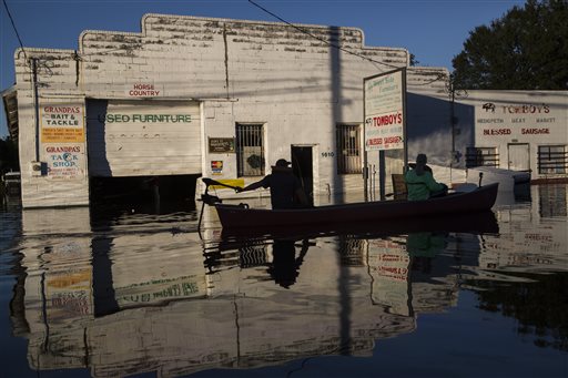 Ryan Christian and Delores Miller canoe down West 5th Street after checking on Miller's elderly mother's home in downtown Lumberton after Hurricane Matthew caused downed trees