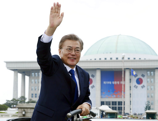 South Korea's new President Moon Jae-in waves from a car after his inauguration ceremony outside of the National Assembly in Seoul