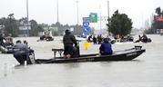 Volunteer rescue boats make their way into a flooded subdivision to rescue stranded residents as floodwaters from Tropical Storm Harvey rise Monday