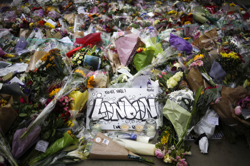 A London poster lays between floral tributes for the victims of Saturday's attack near the London Bridge in London