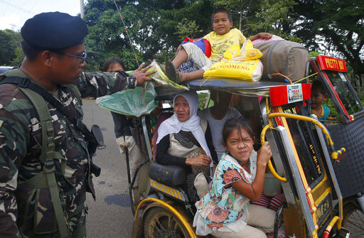 Residents fleeing the besieged city of Marawi are questioned at a checkpoint by government soldiers