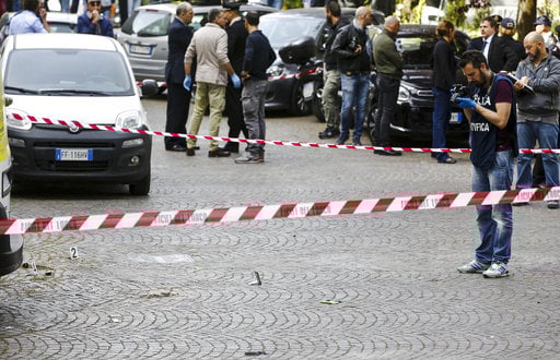 Italian policeman inspect the site where an explosive device blasted off near a post office in Rome