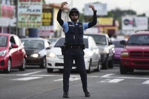 A transit police officer directs the flow of traffic at an intersection in San Juan