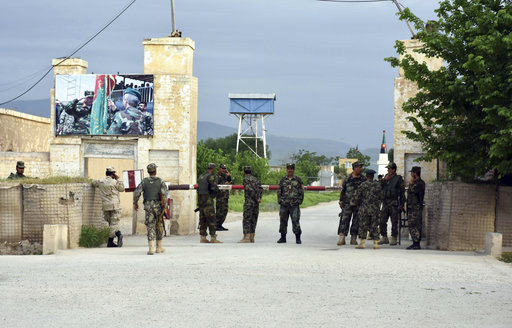 Afghan soldiers stand guard at the gate of a military compound after an attack by gunmen in Mazar-e- Sharif province north of kabul