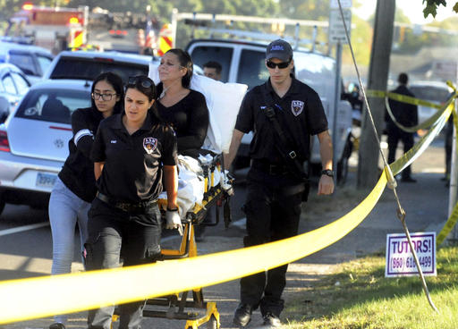 A woman who was on the ground is taken away after a plane crash on Main Street in East Hartford Conn.