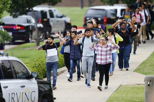 Students and faculty exit a building with their hands up after a fatal shooting at North Lake College in Irving