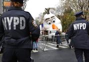 Police officers stand near the site where a large balloon of Olaf