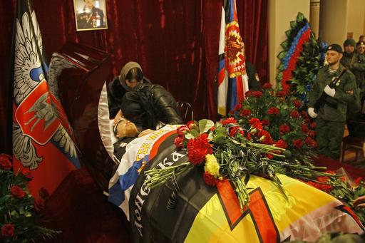 Mourners grieve at the coffin with the body of Arsen Pavlov