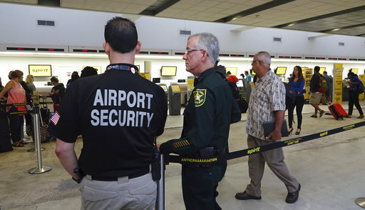 Airport Security and a Broward Sherriff's Deputy keep an eye on the line at Spirit Airlines